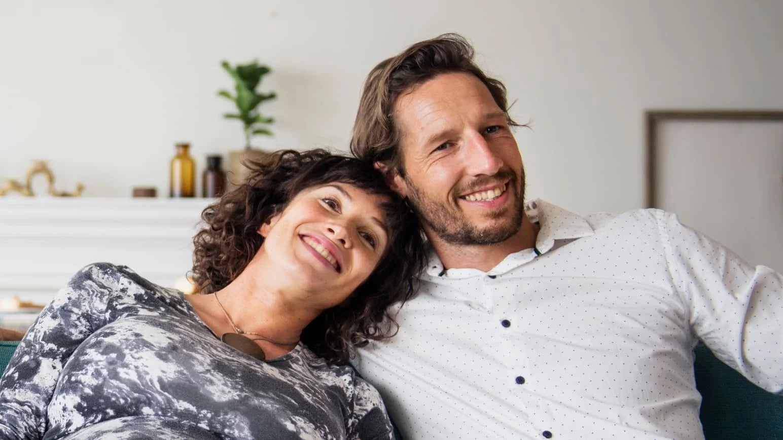 Pareja feliz sentada en el sofá