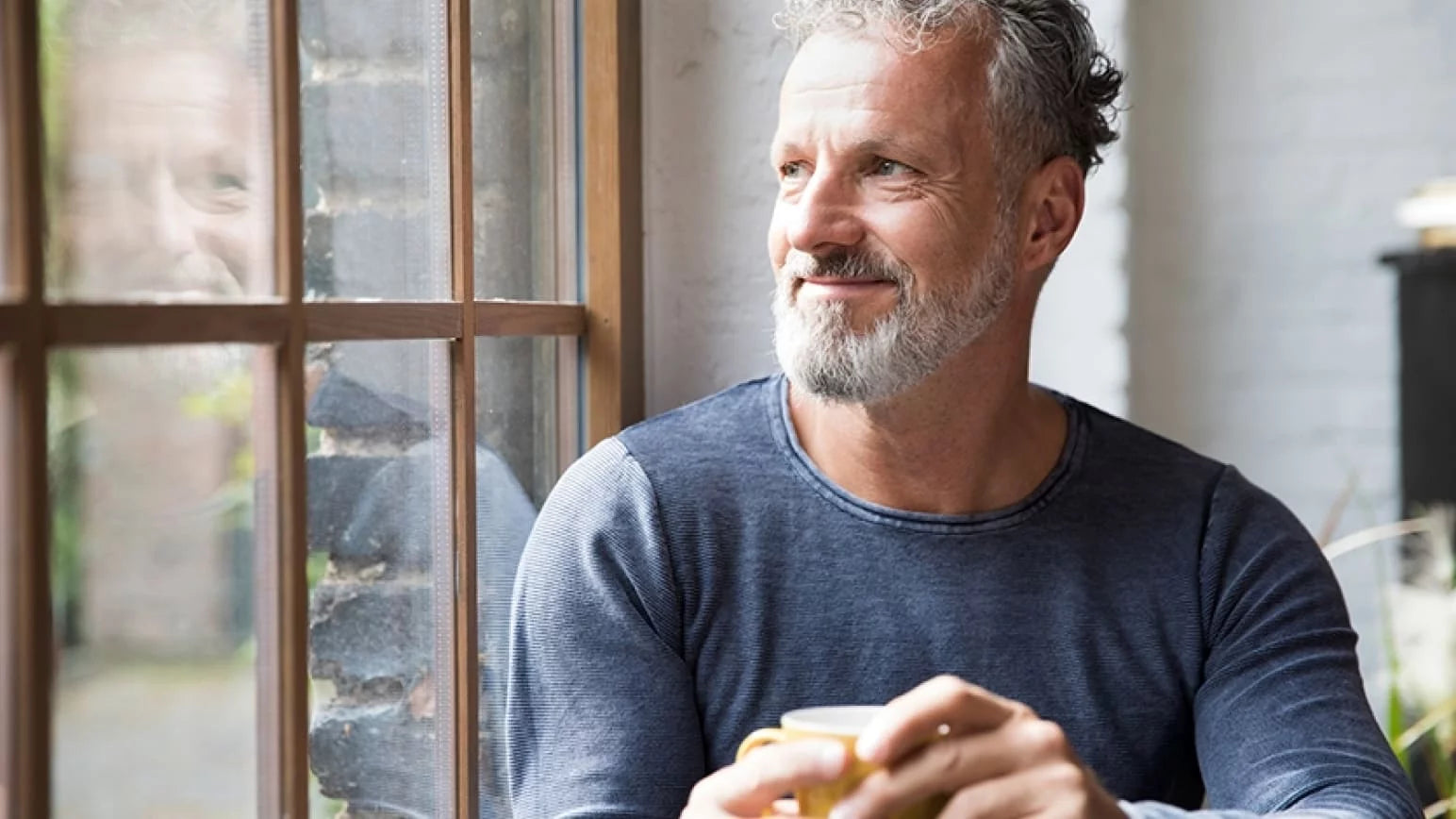 Hombre feliz junto a una ventana
